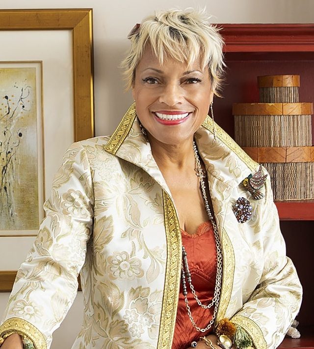 A woman smiling in front of a bookcase.